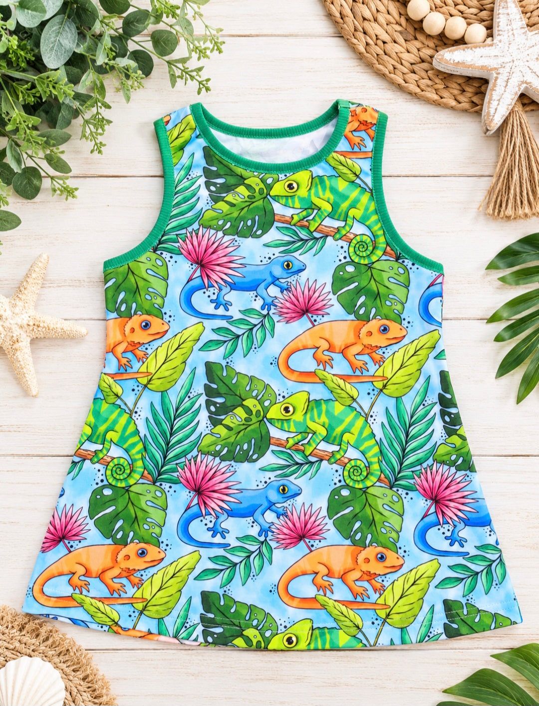 a colorful dress with chameleons and leaves on a white wood surface