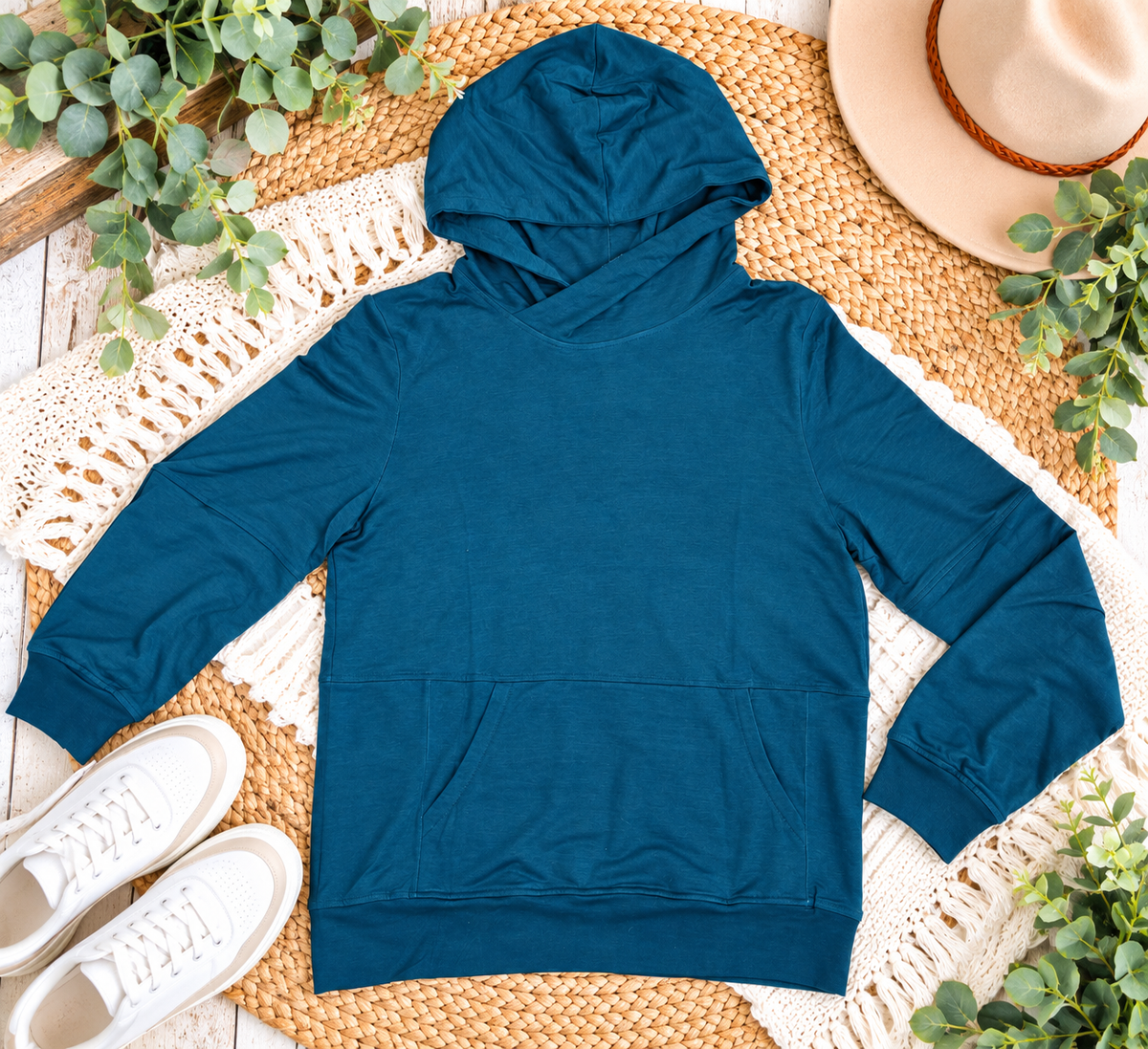 a blue hoodie on a rug next to a hat and shoes