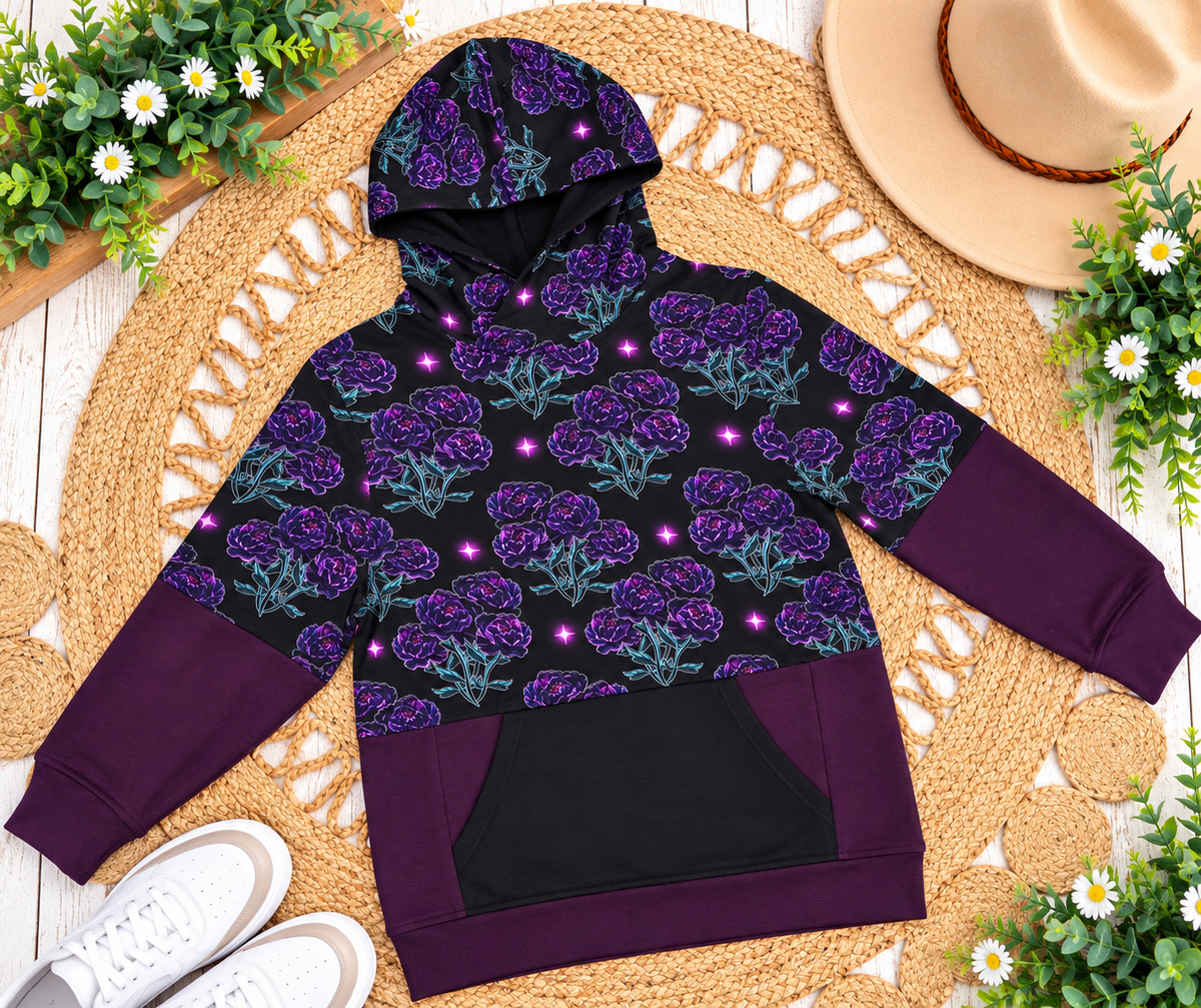 a purple and black hoodie with purple flowers on a woven mat