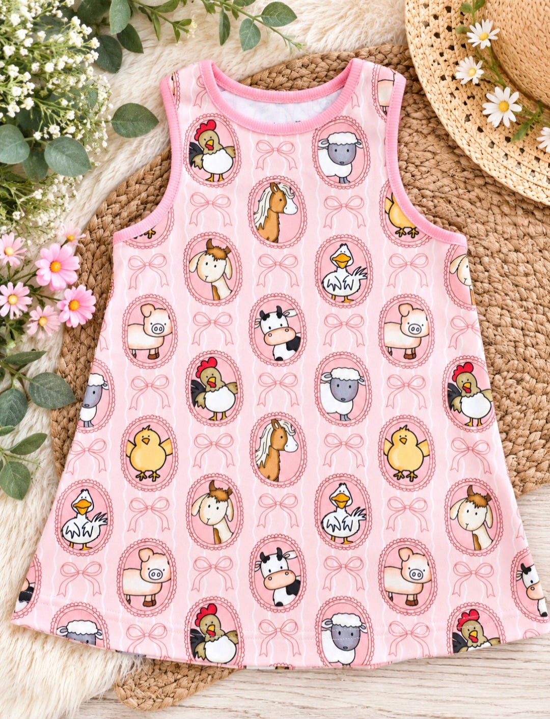 a pink dress with cartoon animals on it